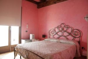 a bedroom with a pink wall with a bed at Marnabianca Apartment in Realmonte