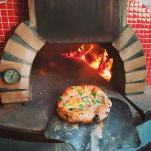 a pizza sitting on top of a fire pit at Albergue Albor in Caldas de Reis