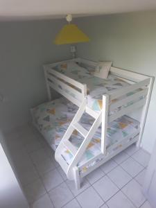 a white bunk bed in a room with a yellow lamp at Gîte de la Bigaillonne in Saint-Marcel