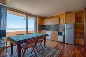 a kitchen with a table and chairs and a window at House In Aguda Beach, praia da Aguda, in Aguda
