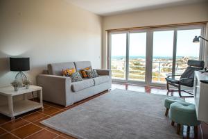 a living room with a couch and a view of the ocean at SEASHORE in Peniche