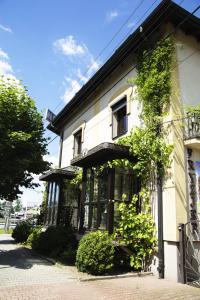 a white building with plants on the side of it at Oberża Złota Gęś in Siewierz