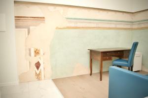 拉戈堡的住宿－Hotel Boutique Castiglione del Lago，墙上的房间里一张桌子和一把椅子