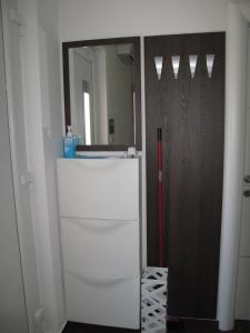 a room with a mirror and a white refrigerator at Apartments Mia Krk in Krk