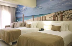 two beds in a room with a mural of a beach at Lagos Atlantic Hotel in Lagos