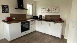 a kitchen with white cabinets and a sink at eifelbleibe in Monschau