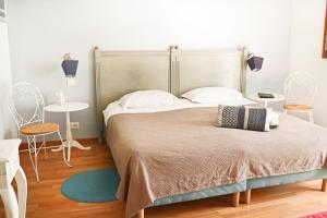 una camera da letto con un grande letto con due tavoli e sedie di A La Villa Boucicaut a Chalon-sur-Saône