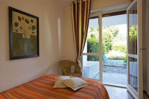 een slaapkamer met een bed en een glazen schuifdeur bij Casa Magnolia in Luino