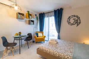 a bedroom with a bed and a table and chairs at Light House - Seafront cosy studio with library in Paphos City