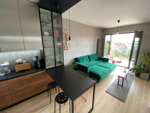 - un salon avec un canapé vert et une table dans l'établissement Apartament DeLux przy Wiśle, à Cracovie