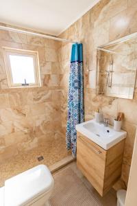 a bathroom with a toilet sink and a shower at Light House - Seafront cosy studio with library in Paphos City