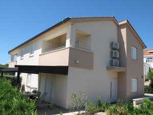 un edificio blanco con un patio enfrente en Apartments Mia Krk, en Krk