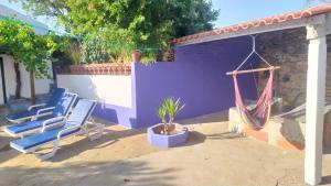 two blue chairs and a hammock on a patio at Casa Menir in Monsaraz