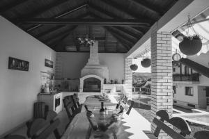 a kitchen and dining room with a table and a fireplace at Pensiunea Gabriel in Corcova