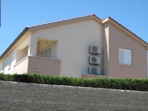 a white building with two air conditioners on it at Apartments Mia Krk in Krk
