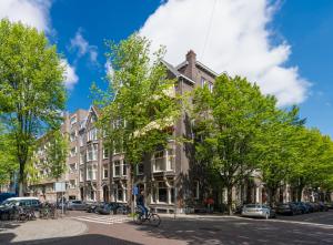 un edificio all'angolo di una strada alberata di De Ware Jacob Boutique Hotel ad Amsterdam