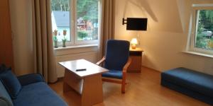 salon z niebieskim krzesłem i stołem w obiekcie Dom Gościnny Przy Lesie w Pobierowie