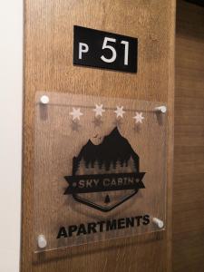 a wooden door with a sign that reads sky caringagents at Sky Cabin Apartments in Kopaonik
