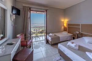 um quarto de hotel com duas camas e uma varanda em Fedriades Delphi Hotel em Delphi