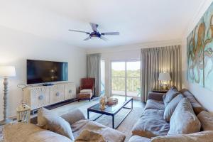 a living room with a couch and a tv at Gulf View from the Summit at Tops'l Beach Resort in Destin