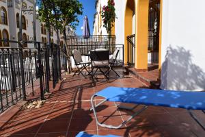 un patio con sillas, una mesa y una valla en Ground Floor Apartment - Opposite pool C, en Playas de Orihuela