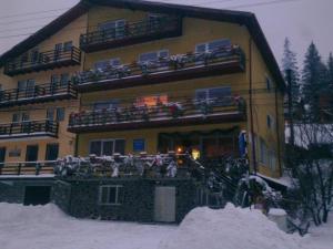 un bâtiment avec des personnes sur les balcons dans la neige dans l'établissement Pensiunea Steluta, à Predeal