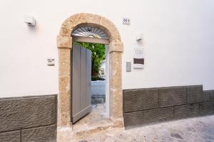 uma entrada para um edifício branco com uma arcada em Corte Sant'Angelo em Monopoli