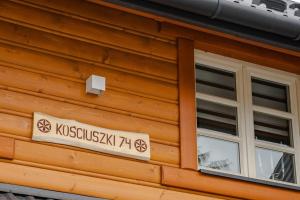 una señal en el lateral de un edificio con ventana en Willa Mnich en Bukowina Tatrzańska