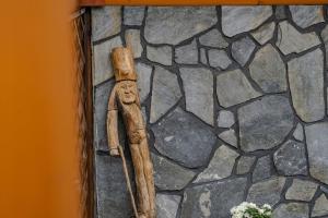 una estatua de madera de un hombre en una pared de piedra en Willa Mnich en Bukowina Tatrzańska