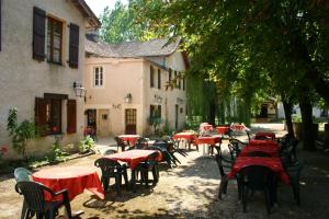 a group of tables and chairs with red tables at Hotel du Parc in Thonac