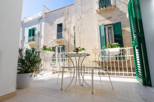 a patio with a table and chairs on a balcony at Corte Sant'Angelo in Monopoli