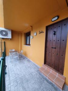 Habitación con puerta de madera, mesa y sillas en BIULES - LA COLINA, en Arnuero