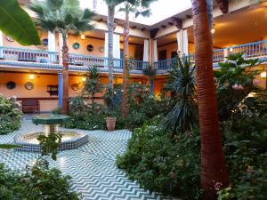 a courtyard in a hotel with palm trees and plants at La Villa Mandarine in Rabat