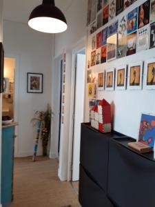 a room with a dresser and a wall with pictures at Appartement cosy et lumineux 1 à 3 personnes in Caen