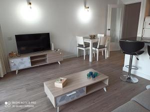 uma sala de estar com uma televisão e uma mesa em Apartaments familiar cerca Port Aventura em Salou