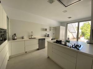 a large kitchen with white cabinets and a large window at Casa Murasaki in La Envia