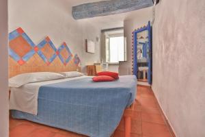 Un dormitorio con una cama azul con almohadas rojas. en CATEO, en Riomaggiore