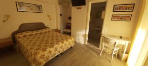 - une petite chambre avec un lit et une chaise dans l'établissement Hotel Casa Popi, à Malcesine