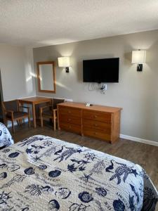 um quarto com uma cama e uma televisão de ecrã plano em Oceanview Inn - Emerald Isle em Emerald Isle