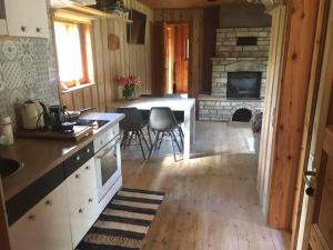 a kitchen with a table and a stone fireplace at Nõmme Holiday Home in Pamma