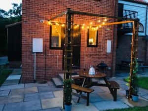 a patio with a table and a ladder with lights at Captain Cook Riverside Walk in Whitby