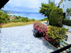 a stone walkway with flowers and a building at Dasea Houses in Ormos Panagias