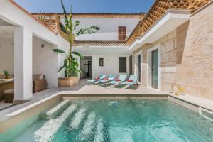 una piscina en una villa con una casa en YupiHome Holiday Home Can Cremat, en Sa Pobla