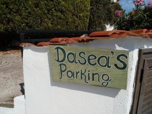 a sign on a wall that readsades parking at Dasea Houses in Ormos Panagias