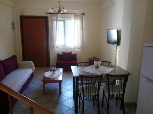 a living room with a table and chairs and a couch at Dasea Houses in Ormos Panagias