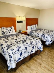 um quarto de hotel com duas camas com lençóis azuis e brancos em Oceanview Inn - Emerald Isle em Emerald Isle