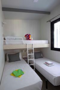 two beds in a room with a bunk bed at Tamarit Beach Resort in Tamarit