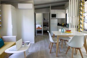 a kitchen and dining room with a table and a laptop at Tamarit Beach Resort in Tamarit