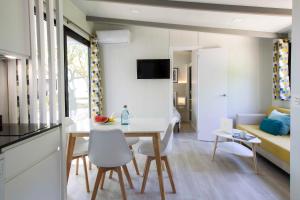a kitchen and living room with a table and chairs at Tamarit Beach Resort in Tamarit