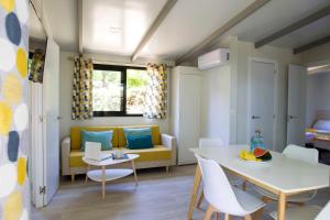 a living room with a table and a yellow couch at Tamarit Beach Resort in Tamarit
